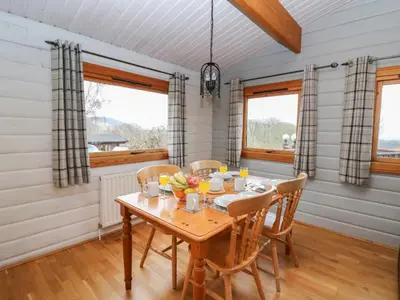 a dining room with a wooden table and chairs at Great Owl Lodge in Rhayader