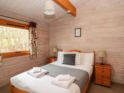 a bedroom with a bed in a log cabin at Great Owl Lodge in Rhayader