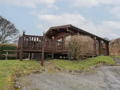 a large wooden house with a large deck at Great Owl Lodge in Rhayader