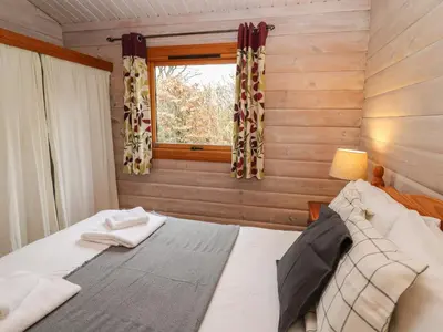a bedroom with a bed and a window at Great Owl Lodge in Rhayader