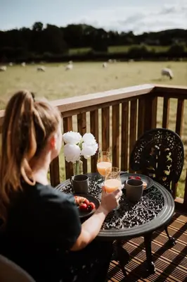 a woman sitting at a table with glasses of juice at The Ginger Nut in Welshpool