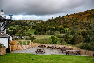 a group of picnic tables and benches on a patio at The Berwyn Arms in Corwen