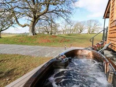 a bath tub with water in it next to a house at Wild Acre in Llangadog