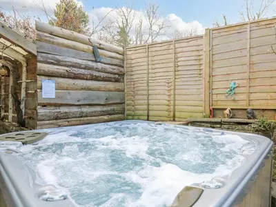 a hot tub in front of a wooden fence at Cringoed House in Aberaeron