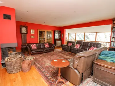a living room with leather furniture and a fireplace at Cringoed House in Aberaeron