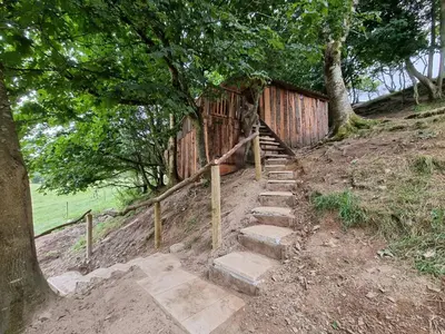 a set of steps leading up a hill with a wooden fence at Tree House in Aberaeron
