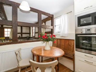 a kitchen with a table with flowers on it at The Old Rectory in Presteigne