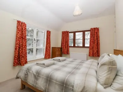 a bedroom with a large bed with red curtains at The Old Rectory in Presteigne