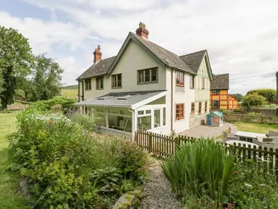 a white house with a fence and a garden at The Old Rectory in Presteigne