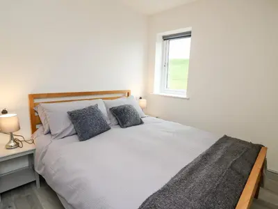 a bedroom with a white bed with two pillows at Brecknock Cheviot - The Sheepfold in Llandrindod Wells