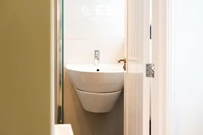a bathroom with a white sink and a mirror at 2 Bedroom Terrace Cottage, Parking, 5 minutes drive to Royal Shrewsbury Hospital in Shrewsbury