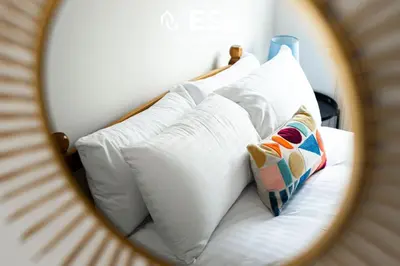 a mirror reflection of a bed with white pillows at 2 Bedroom Terrace Cottage, Parking, 5 minutes drive to Royal Shrewsbury Hospital in Shrewsbury