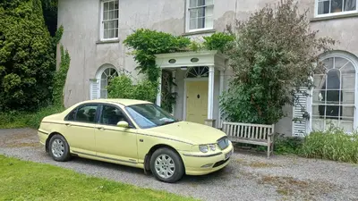 a yellow car parked in front of a house at Gelly Dylan Thomas Paradise in Lampeter