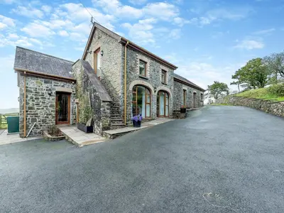 a stone house with a driveway in front of it at Bwlchygwynt in Rhandirmwyn