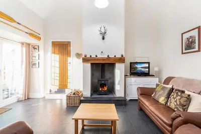 a living room with a couch and a fireplace at The Barn in Bala