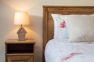 a bedroom with a bed and a lamp on a night stand at The Barn in Bala
