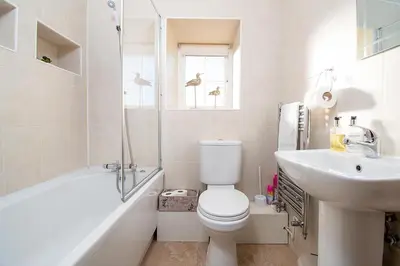 a white bathroom with a toilet and a sink at The Barn in Bala