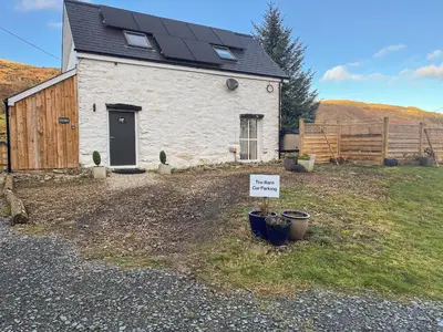 a small house with a sign in front of it at The Barn in Llangwm