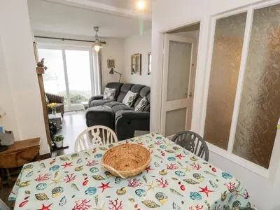 a living room with a table and a couch at Sibrwd Y Mor in Harlech