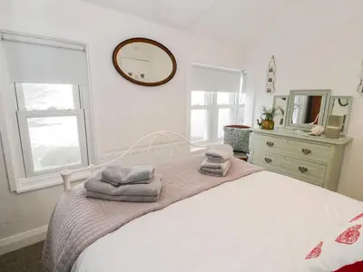 a bedroom with a bed with towels on it at Sibrwd Y Mor in Harlech