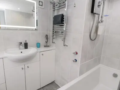 a white bathroom with a sink and a shower at Sibrwd Y Mor in Harlech