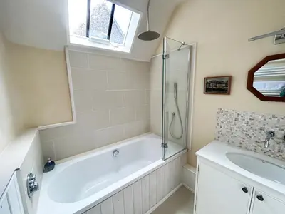 a bathroom with a bath tub and a sink at Trillow House, Clungunford, Ludlow in Clungunford