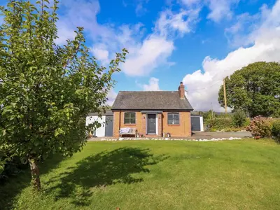 a small brick house with a grass yard at Bethania in Oswestry
