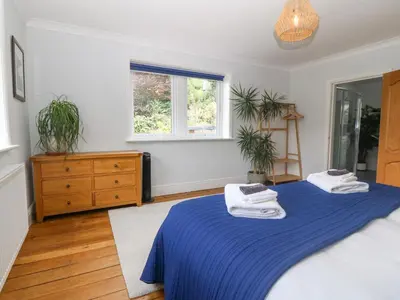a bedroom with two beds and a dresser and a window at Tan Yr Allt in Welshpool