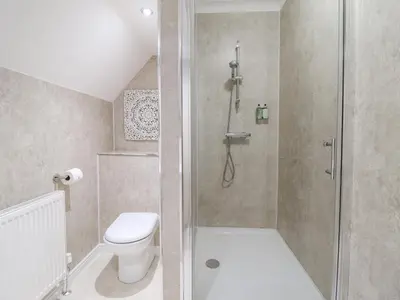 a bathroom with a toilet and a glass shower at Tan Yr Allt in Welshpool