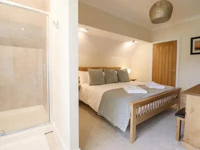 a bedroom with a bed and a shower and a tub at Tan Yr Allt in Welshpool