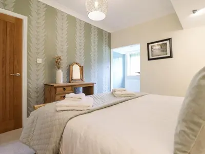 a bedroom with a bed with towels on it at Tan Yr Allt in Welshpool