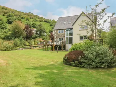 a house with a large yard with a lawn at Tan Yr Allt in Welshpool