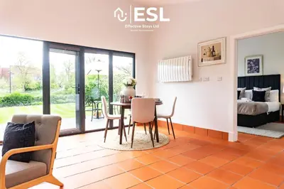 a dining room with a table and chairs and a bedroom at Quarry View Garden Studio in Shrewsbury with Parking in Shrewsbury