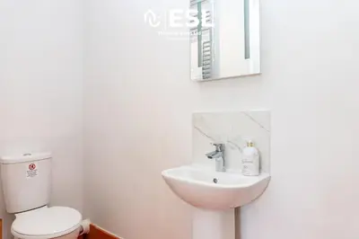 a bathroom with a sink and a toilet and a mirror at Quarry View Garden Studio in Shrewsbury with Parking in Shrewsbury