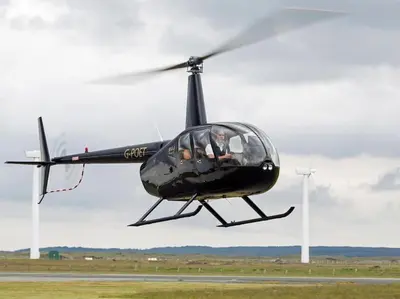 a black helicopter is flying over a runway at Romantic Hideaway in Trawsfynydd