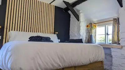 a bedroom with a large white bed and a window at Romantic Hideaway in Trawsfynydd
