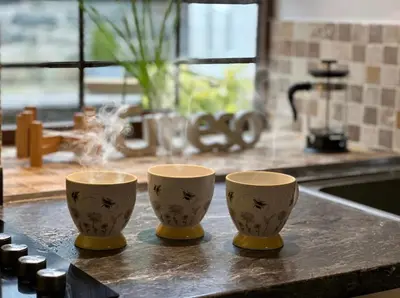 three cups sitting on a counter in a kitchen at Trawsfynydd Stone Cottage in Trawsfynydd