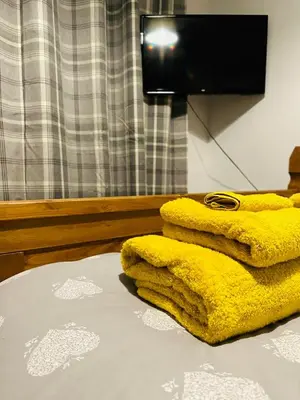 a yellow blanket sitting on top of a bed at Trawsfynydd Stone Cottage in Trawsfynydd