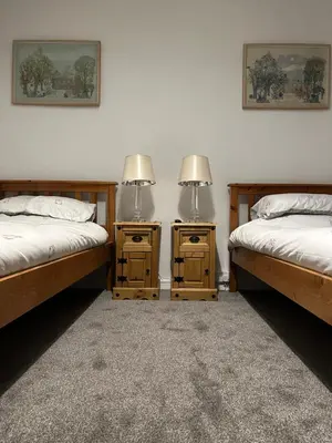 two twin beds in a room with two night stands at Trawsfynydd Stone Cottage in Trawsfynydd