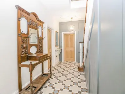 a hallway with a mirror and a tiled floor at Belle Vue in Hereford