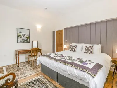 a bedroom with a large bed and a desk at Belle Vue in Hereford