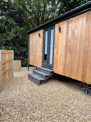 a tiny house with a door and a set of stairs at Dee Lodge with private hot tub in Llangollen