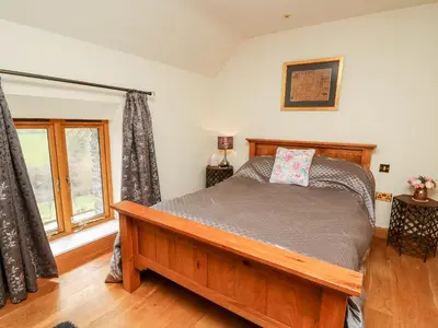 a bedroom with a bed and a window at The Orchard in Knighton