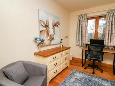 a living room with a desk and a dresser at The Orchard in Knighton
