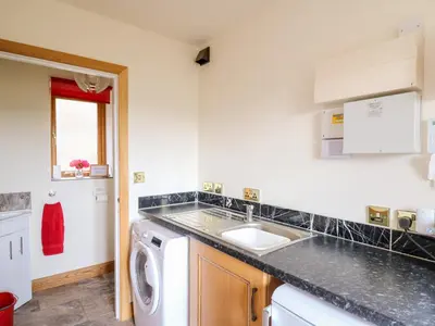 a kitchen with a sink and a washing machine at The Orchard in Knighton