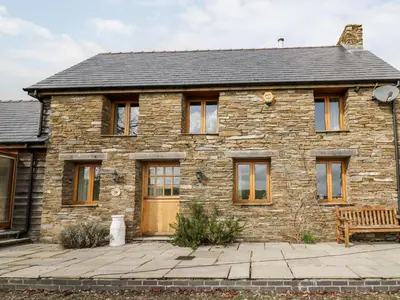 a stone house with a bench in front of it at The Orchard in Knighton