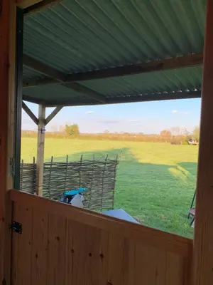 a view of a field from a screened in porch at Willowdene shepherds hut in Oswestry