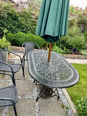 a table with a green umbrella on top of it at River walk . Shrewsbury.Shropshire.With parking. in Shrewsbury