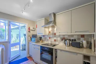 a kitchen with white cabinets and a stove top oven at St. John’s hill - with parking in Shrewsbury