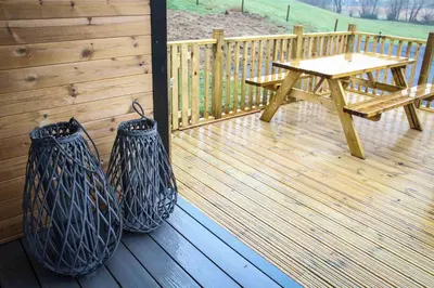 a wooden deck with a picnic table and a bench at Fawns Rest in Nantmel